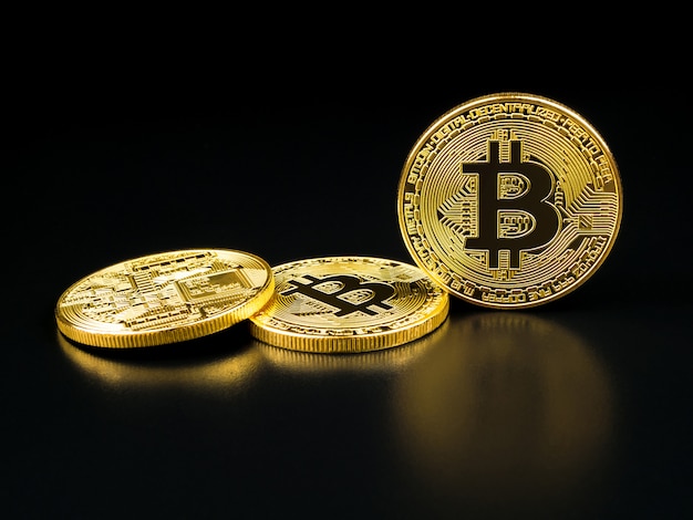 Golden bitcoin on black .