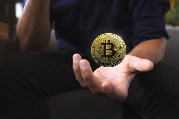 Golden bitcoin in a businessman hand in the office