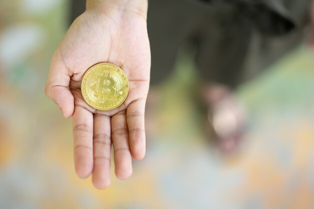 Golden bitcoin coin in women hands