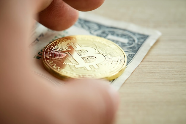 Golden Bitcoin coin on wood background