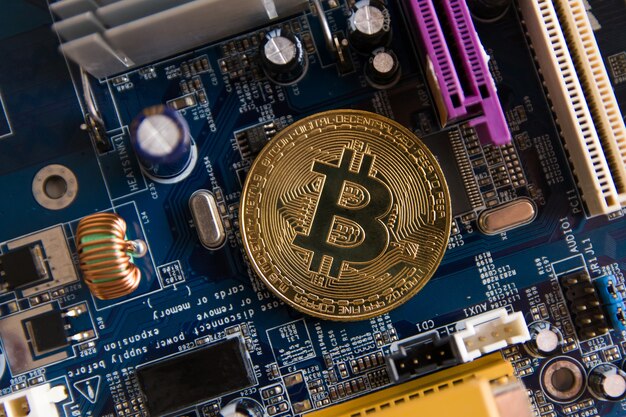 マザーボード上のゴールデンBitcoinコイン、回路板付きのマイナー、プールのCryptocurrency