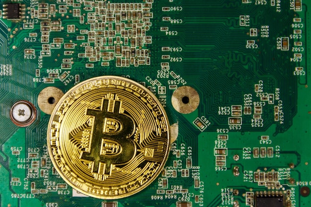 Golden bitcoin on a computer motherboard. Cryptocurrency virtual money