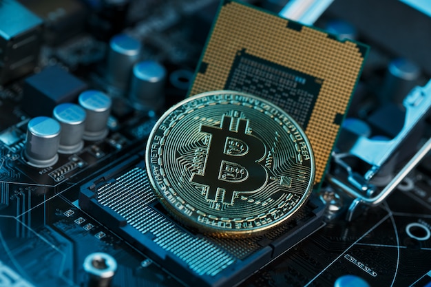 Golden Bitcoin Cryptocurrency on computer circuit board CPU