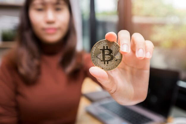 Foto bitcoin dorato (criptovaluta) a disposizione della donna di affari