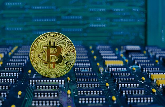 コンピューターの電子回路基板の背景にゴールデンビットコイン暗号通貨の新しいバージョン