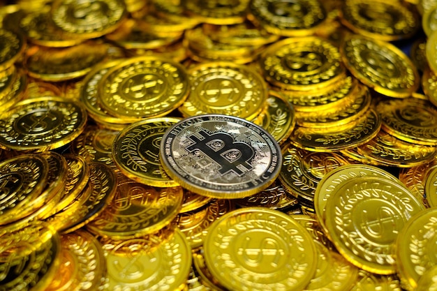 Criptovaluta bitcoin dorato su monete d'oro in mucchio molto