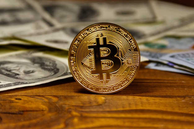 Golden bitcoin and dollars on wooden background