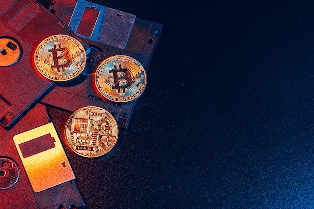 Golden bitcoin on floppy disk on dark background