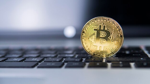 Golden bitcoin on a laptop bitcoin crypto currency on a\
computer black keyboard digital currency virtual money metal coins\
of bitcoin bussiness commercial exchange