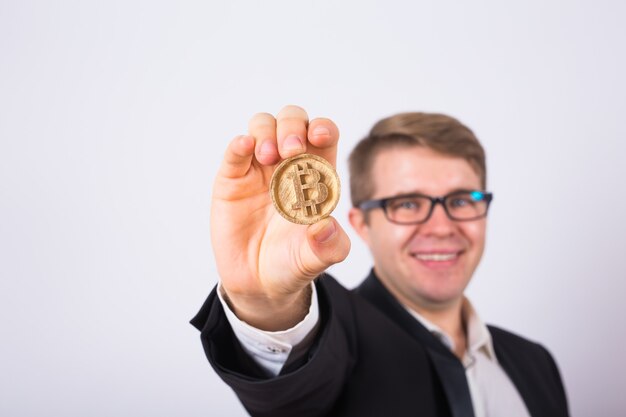 Golden Bitcoin in a man hand, Digital symbol of a virtual cryptocurrency.