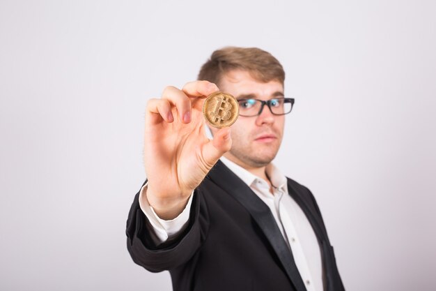 Golden Bitcoin in a man hand, Digital symbol of a virtual cryptocurrency