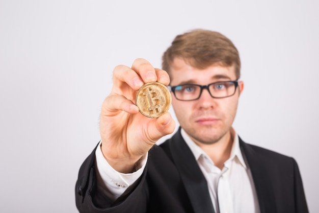 Golden Bitcoin in a man hand, Digital symbol of a virtual cryptocurrency.