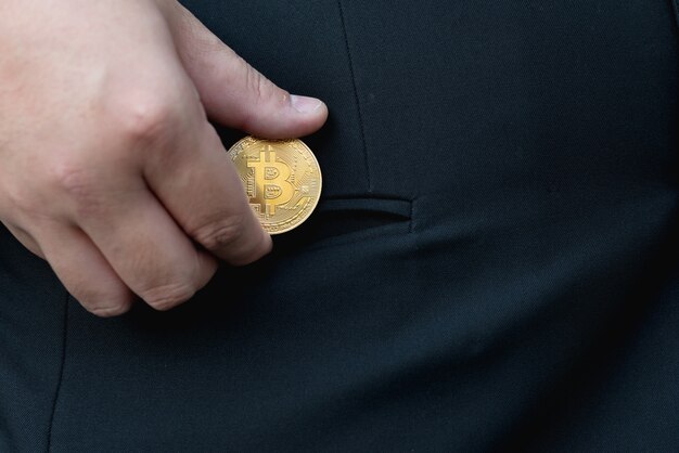 Golden Bitcoin in a man hand, Digitall symbol of a new virtual currency.