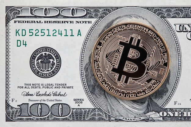 100달러 지폐 배경에 황금 bitcoin