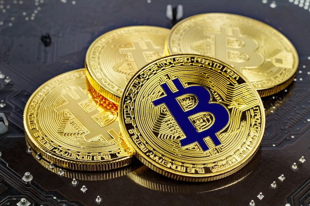 Golden bitcoins on black surface closeup