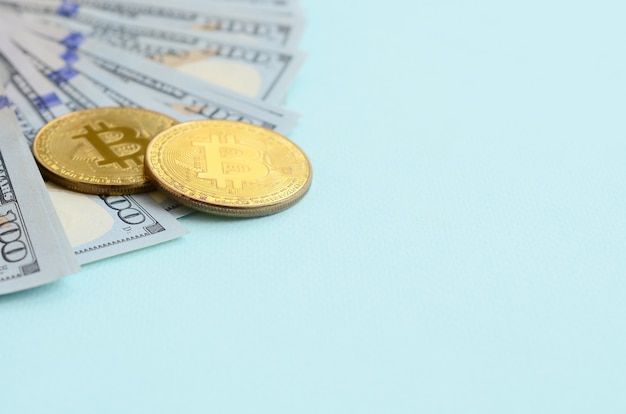 Golden bitcoins and hundred dollar bills lies 