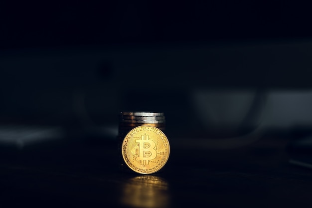 Golden bitcoins placed on a wooden desk in the house.