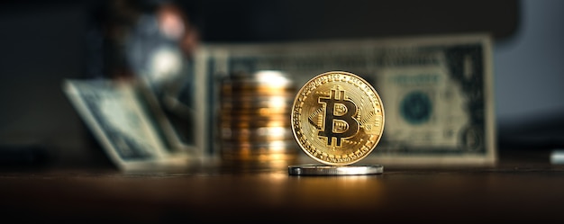 Golden bitcoins placed on a wooden desk in the house.