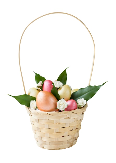 Foto uova di pasqua in bronzo dorato e rosa con foglie verdi e fiori in cesto isolati su sfondo bianco elemento di design per poster o banner di biglietti di auguri