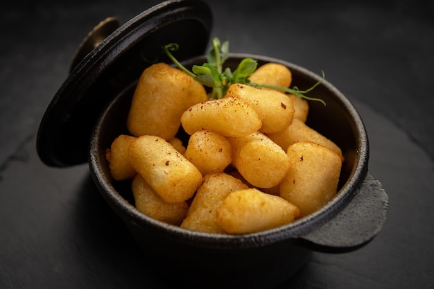 Golden brown nuggets in a castiron dish on a stone