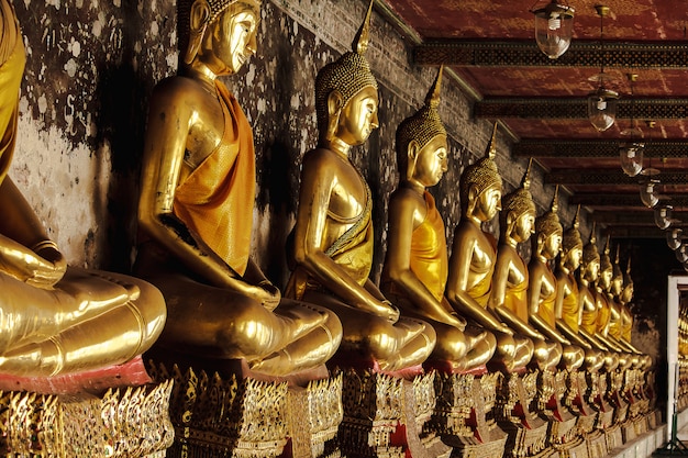 Photo golden buddha beside old walls in thai temples