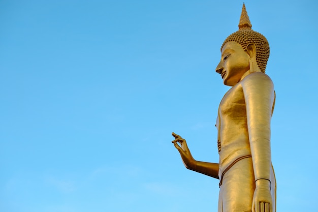 Golden buddha on blue sky backgrond with copy space