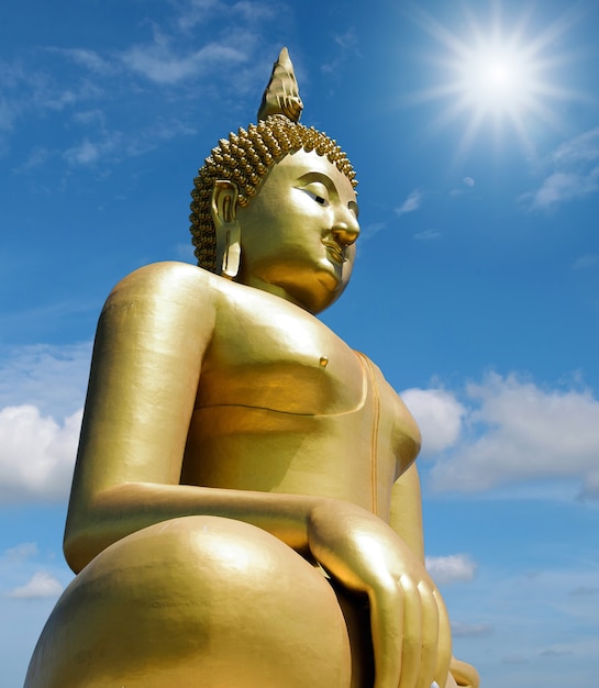 Golden Buddha statue isolated on blue sky