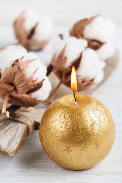 Golden candle with cotton flower