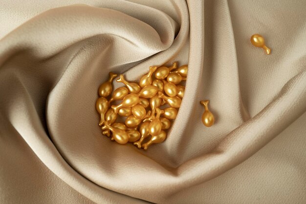 Golden capsules of the face serum or essential oil for face massage lying on a beige fabric