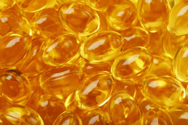 Golden capsules of Vitamin Omega 3 Fish Oil closeup in full screen