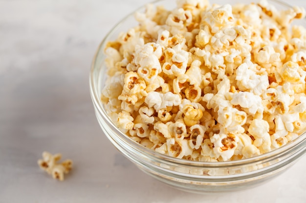 Golden caramel popcorn in glass bowl, copy space.