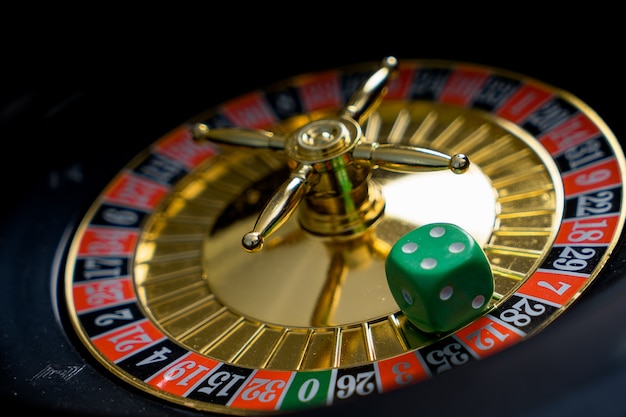 Foto tema del casinò d'oro. immagine ad alto contrasto della roulette del casinò, fiches da poker su un tavolo da gioco