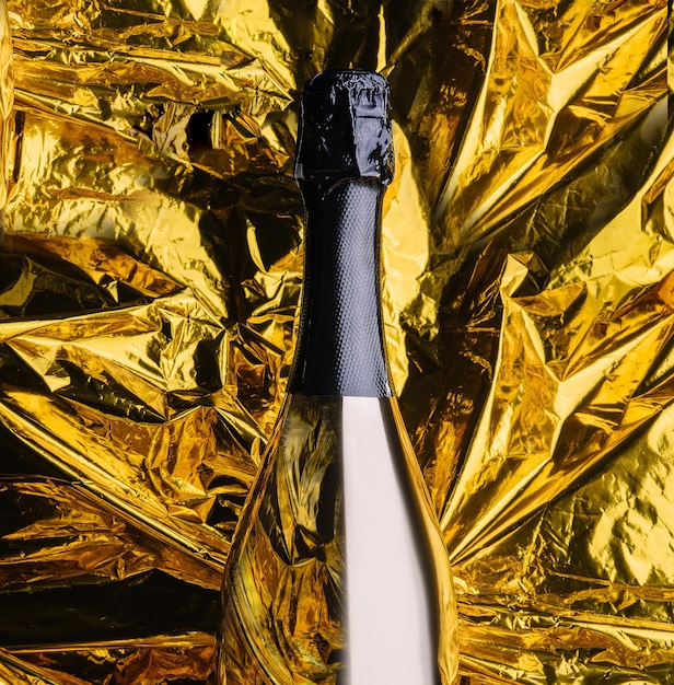 Foto bottiglia di champagne dorata su lamina d'oro