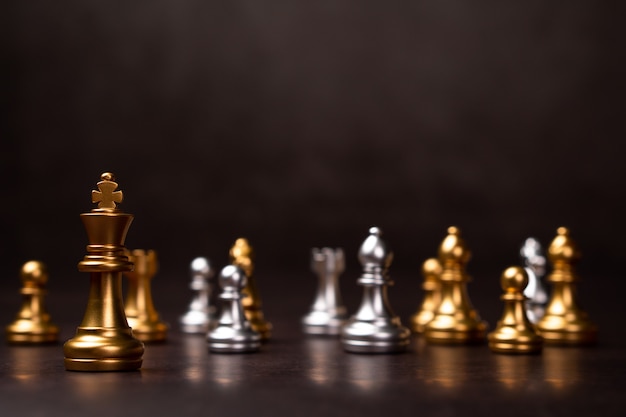 Golden chess king in piedi per essere in giro con altri scacchi il concetto di un leader deve avere coraggio