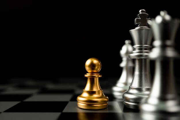 Golden Chess pawn standing in front of other chess Concept of a leader must have courage and challenge in the competition leadership and business vision for a win in business games