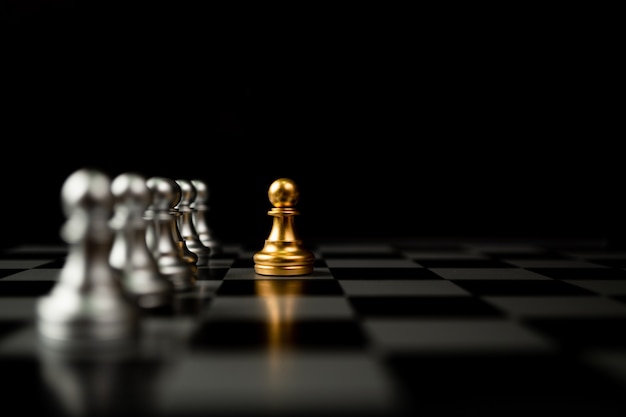 Golden Chess pawn standing in front of other chess, Concept of a leader must have courage and challenge in the competition, leadership and business vision for a win in business games