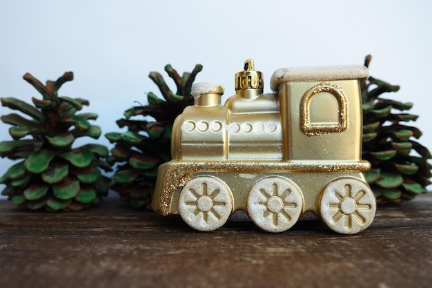 Photo golden children's toy train cones painted with green gouache like small christmas trees new year or christmas card icicles and snow on the train festive background christmas decorations