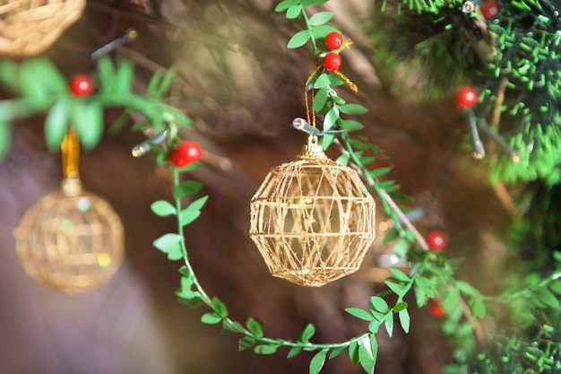 Golden christmas balls on green plastic firwith red berries. Golden Christmas decoration on Christmas tree