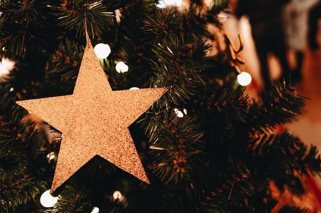 Golden Christmas decoration on the Christmas tree Toy in the form of a shiny star Merry Christmas