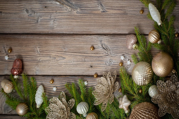 Golden christmas toys with fir branches on dark wooden background