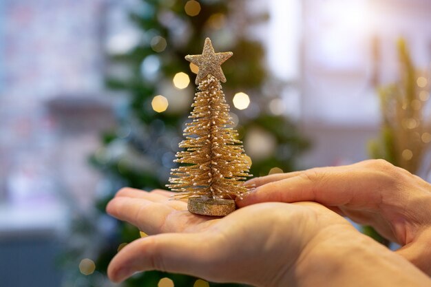 Foto albero di natale dorato nel palmo della tua mano