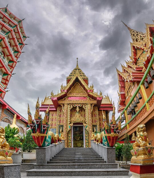 Golden church with storm in the sky inside of Wat Tham Sua Temple