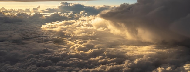 Горизонт неба с золотыми облаками во время восхода солнца в воздухе, вид из окна самолета