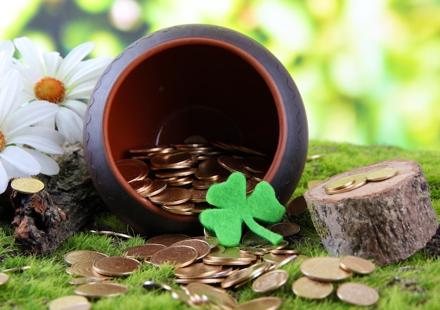 Golden coins falling out from pot on bright background