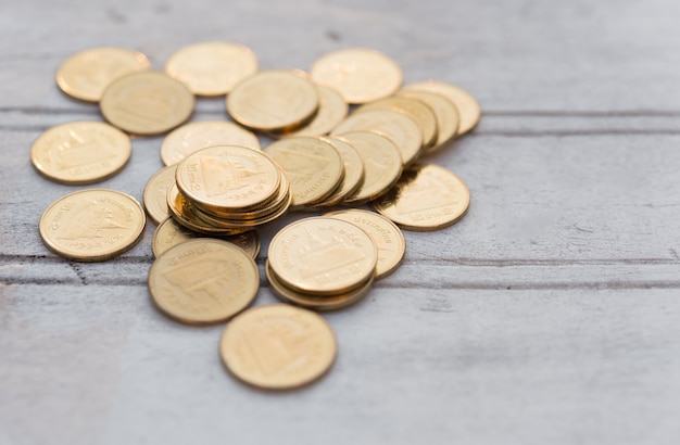 Photo golden coins on old white wooden table