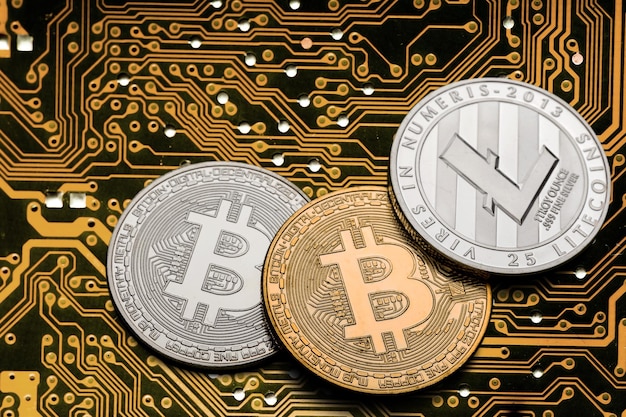 Golden coins with bitcoins symbol on a mainboard.