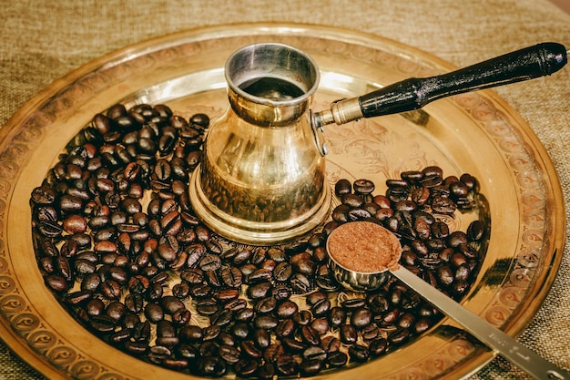 Golden colour metal plate full of coffee beans and coffee maker