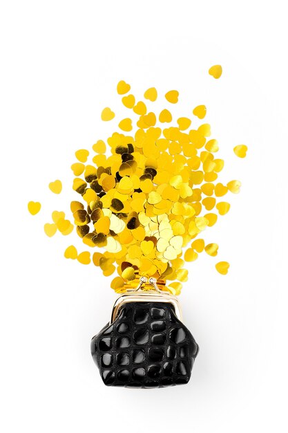 Golden confetti falling out of  purse on white background