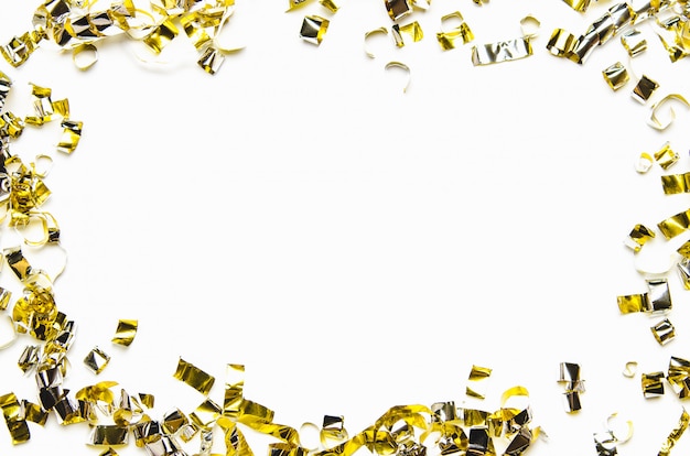 Golden confetti and foil tape on white background. 