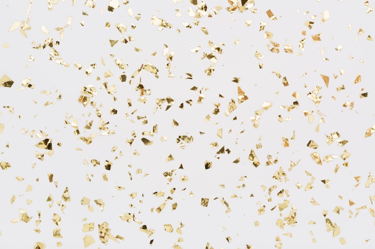 Photo golden confetti on white background. festive, party or holiday glitter backdrop. flat lay.